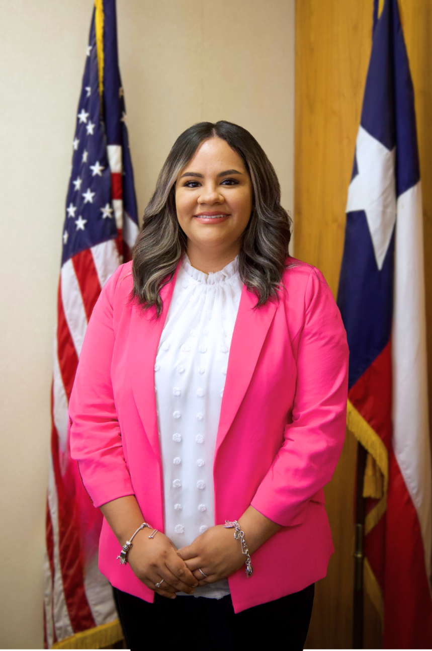 Wendy Lujan standing in front of an American and Texas flag.